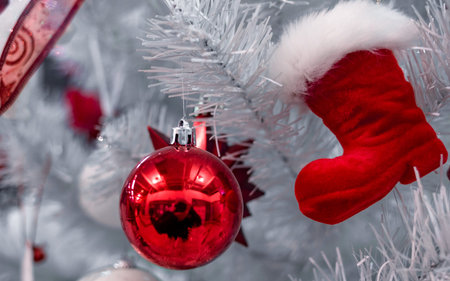 Beautiful Christmas red and silver balls on a white Christmas tree with decorations in the form of...