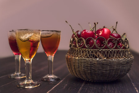 Alcoholic drinks in glass piles on a wooden table. Cherry, nut and lemon liqueurs.