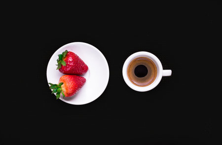 Strawberries and cup of coffee on black background, top viewの写真素材