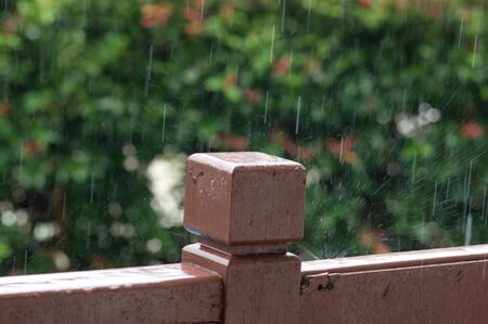Rain drops on wooden railingの写真素材