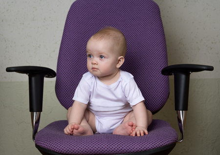 the infant sits on the office chairの写真素材
