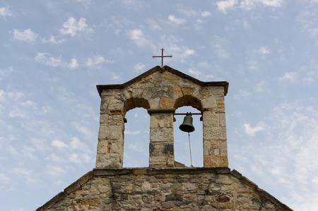 bell tower with bell and cross of a church in Sardiniaの写真素材