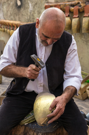 Tonara, Sardinia, Italy - October 5, 2014: a craftsman realizes cowbells during the festival Autumn in Barbagia. Tonara, Sardinia, Italy.のeditorial素材