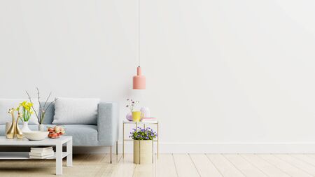 Empty living room with blue sofa, plants and table on empty white wall background. 3D renderingの写真素材