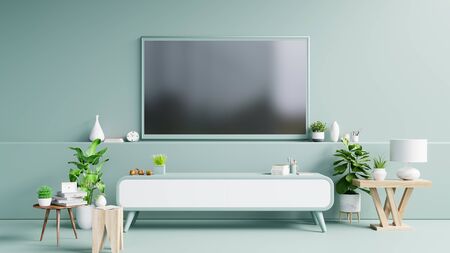 TV on the cabinet in modern living room have plants and book on green wall background,3d renderingの写真素材