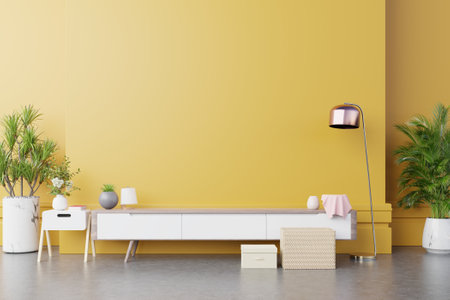 Cabinet TV in modern living room with lamp,table,flower and plant on yellow wall background,3d renderingの写真素材