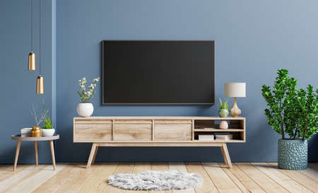 Mockup television on cabinet in contemporary empty room with dark blue wall behind it.3D renderingの写真素材