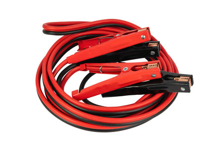 Electricity through jumper cables isolated on a white background. Red and black cables.の写真素材