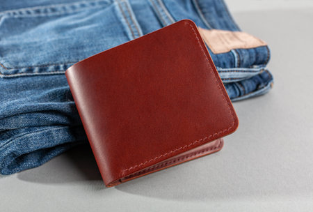 Brown leather wallet on a denim background.の写真素材