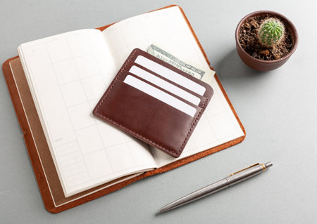 Leather cardholder with dollars and cards on the diary.の写真素材