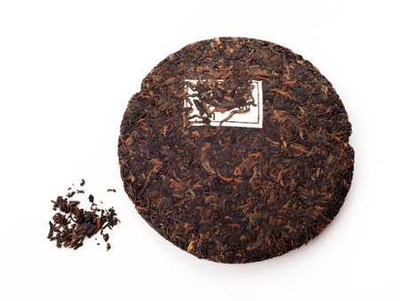 A piece of chinese tea shu puer isolated on white background. Fermented traditional tea.の写真素材