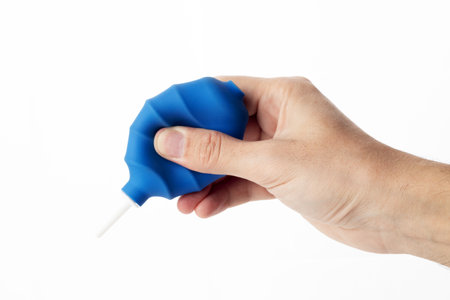 Man holding manual hand pump air blower or rubber dust blower. Cleaning optics and camera lensの写真素材