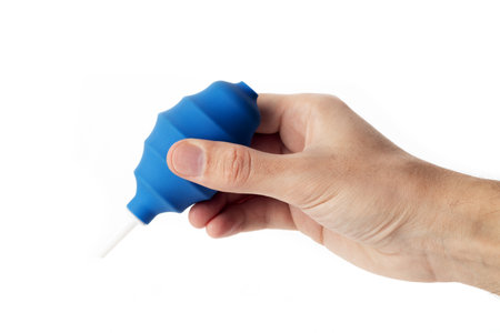 Man holding manual hand pump air blower or rubber dust blower. Cleaning optics and camera lensの写真素材