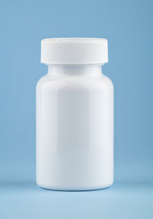 White medical container of pills on light blue background. Drugs and health supplement pills into medicine white bottle health care and medical top view on colored blue background.の写真素材