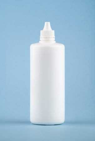 White medical liquid container on light blue background. Plastic blank bottle health care and medical top view on colored blue background.の写真素材