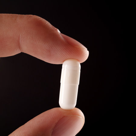 Heading The pill on the finger extra close up. The white pill extra macro view.の写真素材