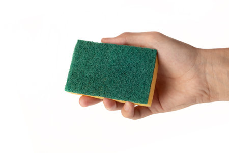 Sponge for washing and cleaning in male hand. Hand isolated on white. A hand holds a sponge for washing and cleaning.の写真素材