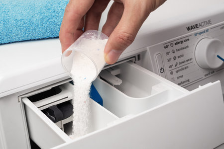 Putting the washing powder in the washing machine. The concept of laundry.の写真素材