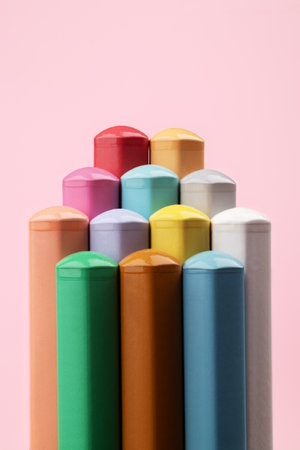 Colored pencils of pastel colors on a pink background. Abstract pyramid of pencils. Multi-colored pastel pencils.の写真素材