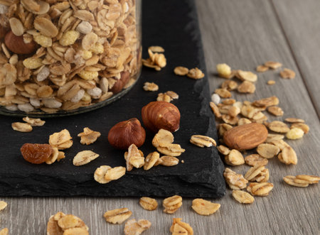 Muesli with hazelnuts and almonds on a wooden table.
