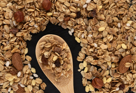Granola with nuts and raisins on a wooden spoonの写真素材