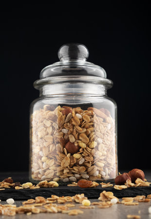 Healthy granola with nuts and muesli in glass jarの写真素材