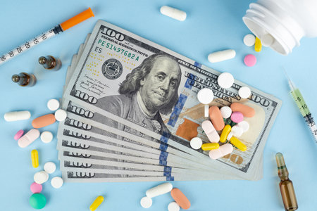 Pills, capsules and dollars on a blue background. Top viewの写真素材