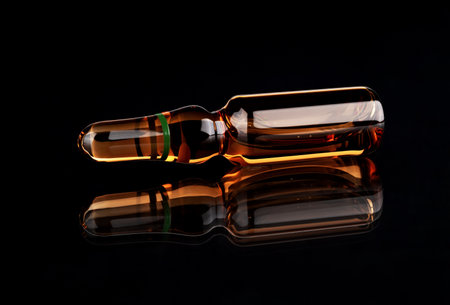 Medical ampoule on a black background with reflection. Medicine conceptの写真素材