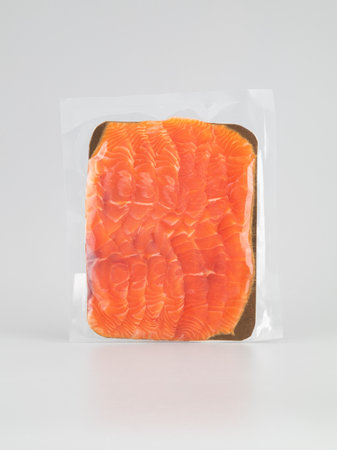 Sliced raw salmon fillet in plastic bag on white backgroundの写真素材