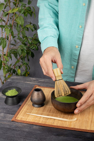 Man making matcha tea ceremony in a bamboo bowl, closeupの写真素材