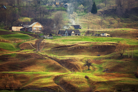 Foggy spring morning in mountain village. Fields and hillsの写真素材
