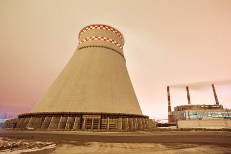 Power plant and cooling towers at dusk near the cityの写真素材