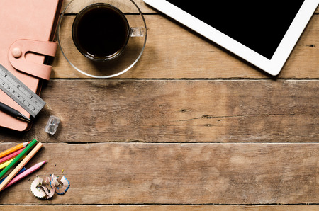 Office stuff with tablet, coffee cup ,colour pencil, pen,ruler and leather notebook.Top view with copy spaceの写真素材