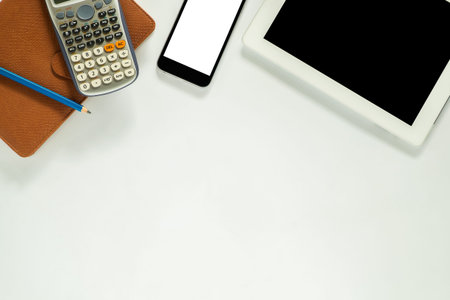 White office desk table with tablet computer , pencil, leather notebook, calculator and blank screen...