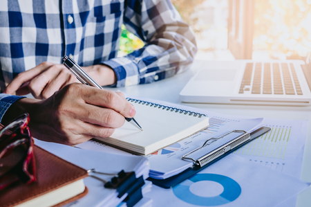 Businessman hands with pen writing notebook  on office desk table close up. Business concept.の写真素材