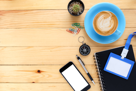 Office desk table with notebook,smart phone,pen,name card and cup of coffee.Top view with copy space.Office desk table concept.の写真素材