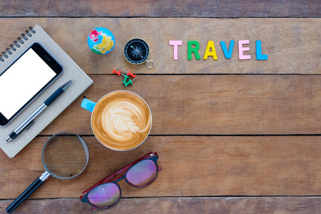 Caption word  travel. Office desk with notebook, pen, smart phone and cup of coffee on white background.top view with copy spaceの写真素材