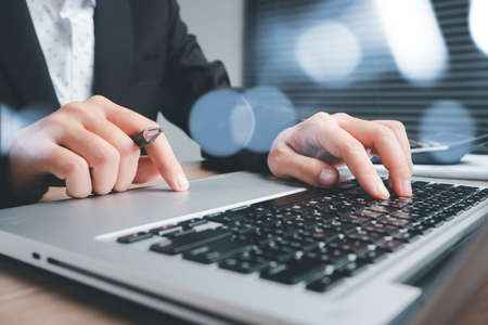 Businesswoman working in office interior on laptop computer on desk.の写真素材