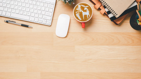 Flat lay, Wooden office desk with notebook, keyboard computer, eyeglass, mouse, pen and coffee, Top view with copy space, Mock up.の写真素材