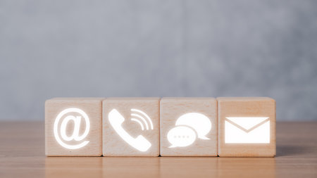 Contact us or Customer support hotline people connect, Wooden blocks with contact us icon on dark background.の写真素材