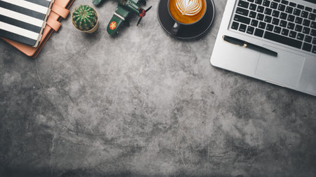 Dark office desk workplace with laptop, pen, notebook and cup of coffee, Top view flat lay with copt space.の写真素材