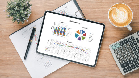 Tablet screen display with charts and reports on office desk workplace. Top view flat layの写真素材