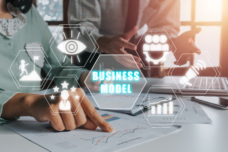 Business model and planning project concepts, Two business colleagues discussing data on desk with business model icon on virtual screen.の写真素材
