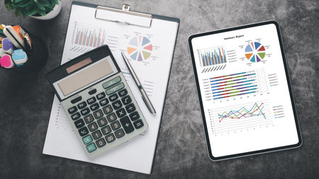 Tablet with charts and reports on office desk workplace. Top view flat layの写真素材