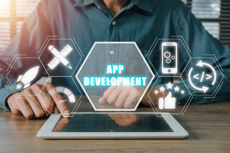 App development concept, Person hand using digital tablet with app development icon on virtual screen background, Designing application for mobile phone.の写真素材
