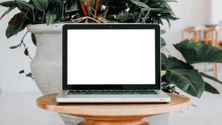 Blank screen laptop computer set up for work on a wooden desk, Mockup, Empty screen, Blank screen for product display.の写真素材