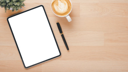 Office wooden desk workplace with blank screen tablet, pen and cup of coffee, Top view flat lay with copy space.の写真素材