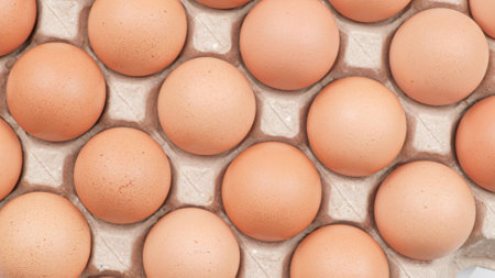 Top view, Chicken eggs in carton box on wooden table, Close upの写真素材
