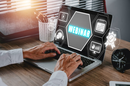 Webinar e-learning training business internet technology concept. Person hand using laptop computer and smart phone with VR screen webinar icon on office desk.の写真素材