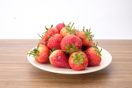 Group of Red strawberries in white bowl on wooden desk, tasty dessert, Close up.の写真素材